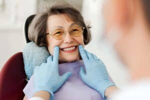A dentist helps an older patient explore tooth replacement options to restore a healthy, confident smile.